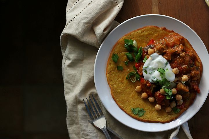 Indian Summer Ratatouille flavored with harissa and cumin seeds, served with curried socca and cilantro lime yogurt. Vegan + Gluten Free. Serves 4.