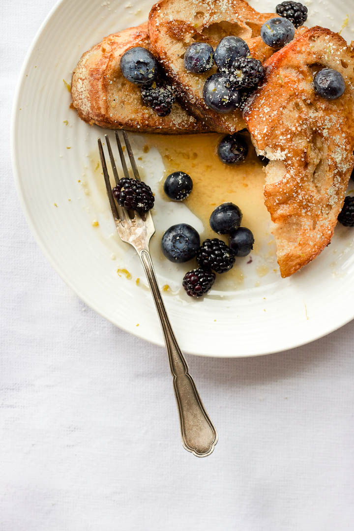 Vegan french toast made with almond milk and flavored with vanilla and cardamom. Summer breakfast done right with fresh berries