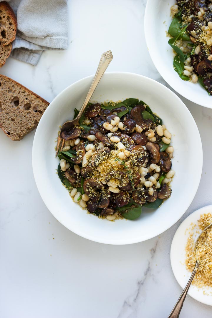 Warm Balsamic Mushroom Salad with Pine Nut Parmesan from The First Mess Cookbook. Loaded with spinach and navy beans. Vegan and Gluten Free. 