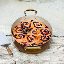 Vegan, whole grain and refined sugar free yeasted summer berry buns flavored with maple, orange and cardamom. Makes 10-15 buns.