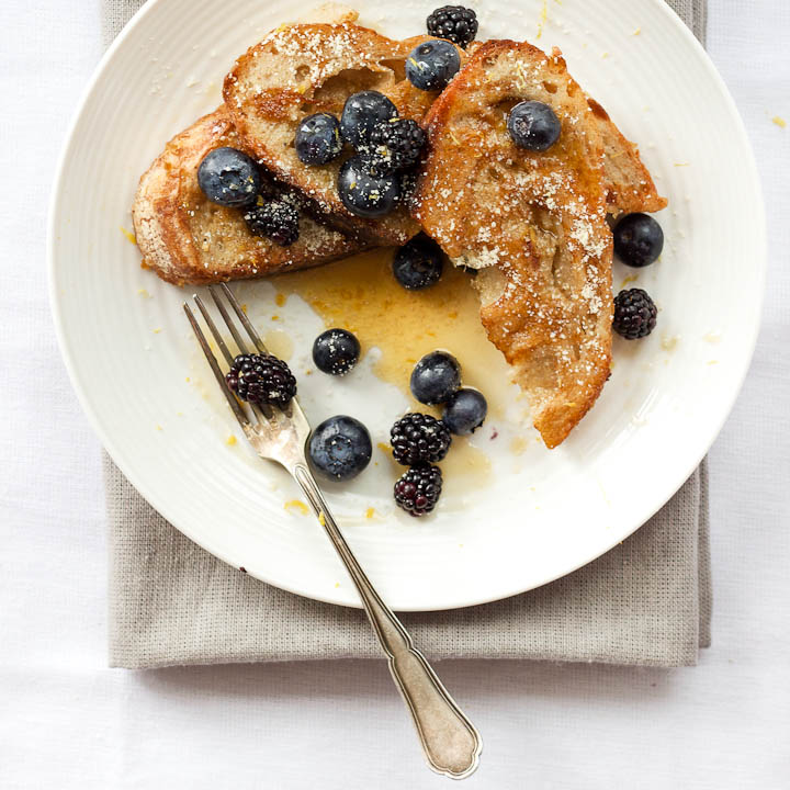 Vegan french toast made with almond milk and flavored with vanilla and cardamom. Summer breakfast done right with fresh berries