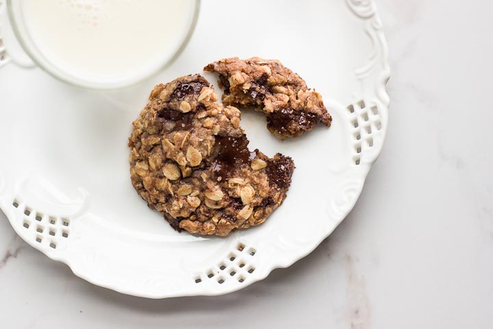 Easy vegan oatmeal cookies that are 100% maple syrup sweetened, made with whole spelt flour and rolled oats and loaded with melted chocolate chunks.